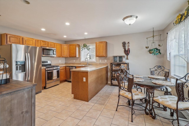 kitchen featuring kitchen peninsula, stainless steel appliances, and sink