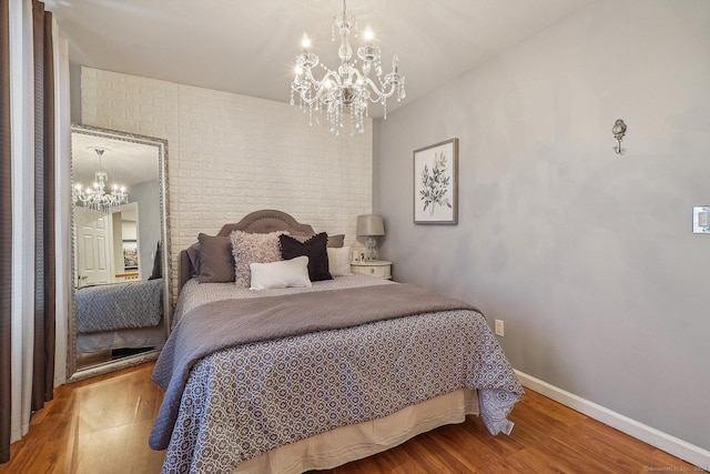 bedroom with wood-type flooring and a notable chandelier