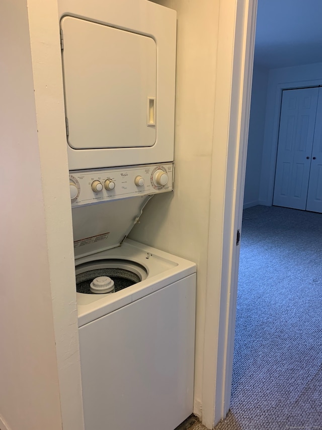 washroom with stacked washer / dryer and carpet