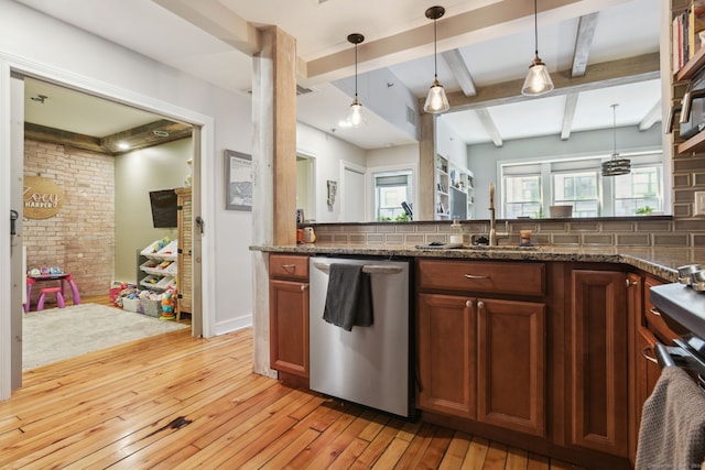 kitchen with backsplash, light hardwood / wood-style floors, stainless steel dishwasher, and dark stone countertops