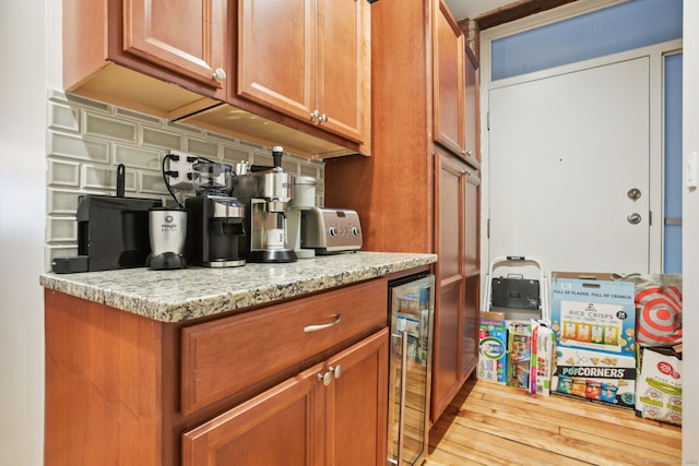 kitchen with light stone counters, beverage cooler, and light hardwood / wood-style floors