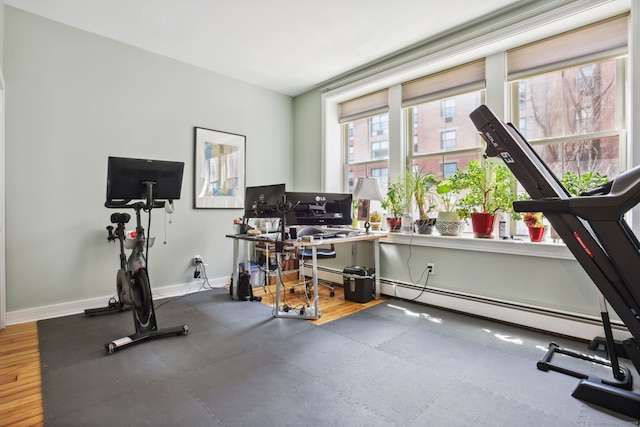 workout area featuring wood-type flooring and a baseboard radiator