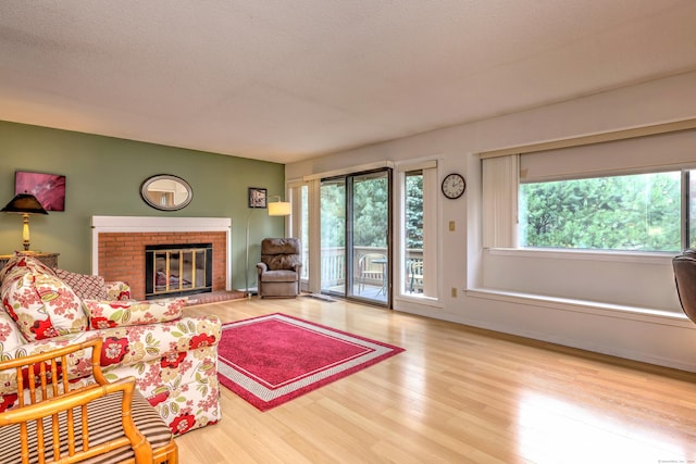 living room featuring a fireplace, wood-type flooring, and a textured ceiling