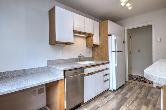 kitchen with sink, white refrigerator, light hardwood / wood-style flooring, dishwasher, and white cabinetry