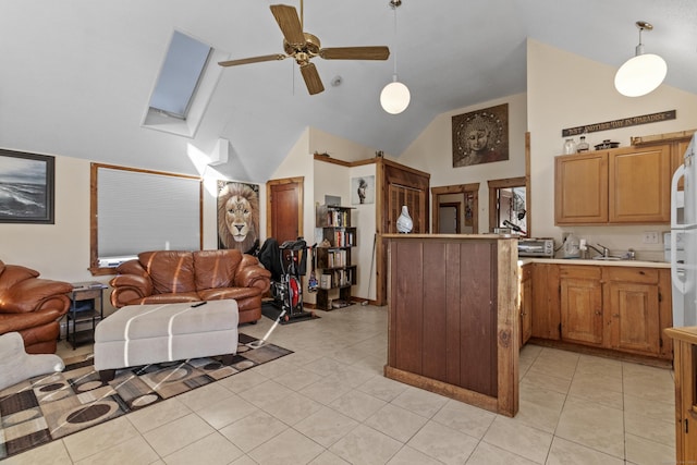 kitchen featuring kitchen peninsula, ceiling fan, lofted ceiling with skylight, and hanging light fixtures