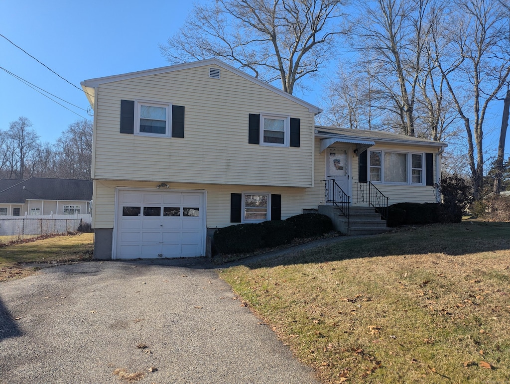 split level home featuring a garage and a front yard