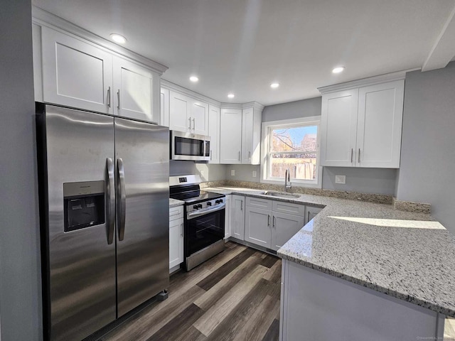 kitchen featuring light stone countertops, sink, dark wood-type flooring, white cabinets, and appliances with stainless steel finishes