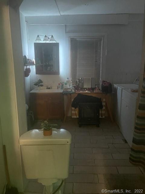 bathroom with washer and clothes dryer, tile patterned flooring, and sink