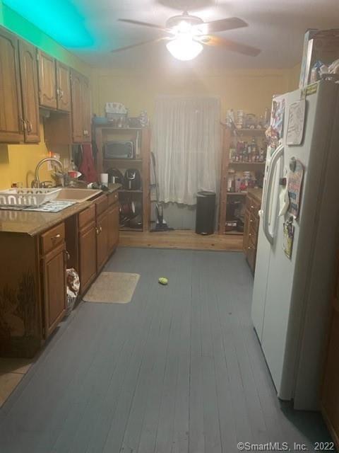 kitchen with white refrigerator with ice dispenser, light wood-type flooring, ceiling fan, and sink