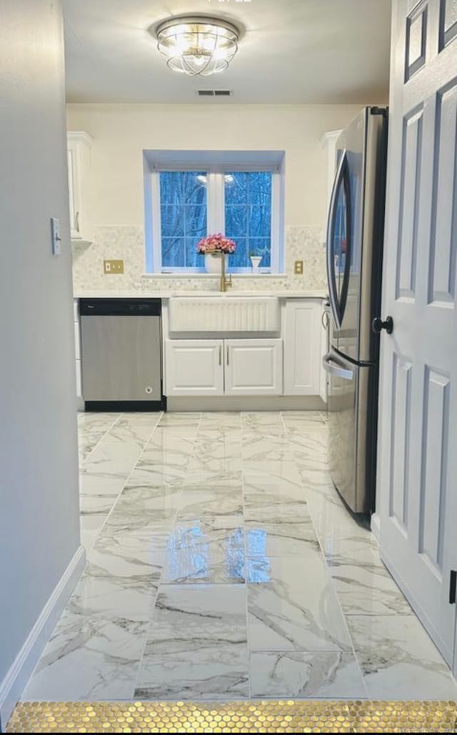 kitchen featuring white cabinets, backsplash, stainless steel appliances, and sink