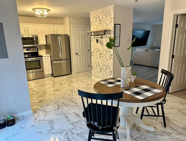 kitchen featuring appliances with stainless steel finishes, electric panel, and white cabinetry