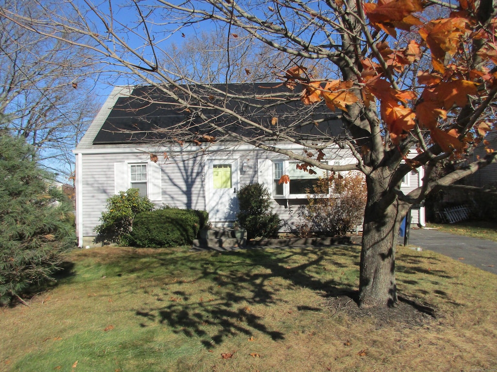 view of front of home with a front yard and solar panels