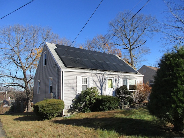 view of property exterior featuring solar panels and a lawn