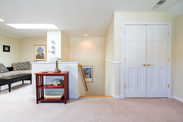 sitting room with a skylight and light carpet