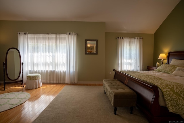 bedroom with light hardwood / wood-style floors and vaulted ceiling