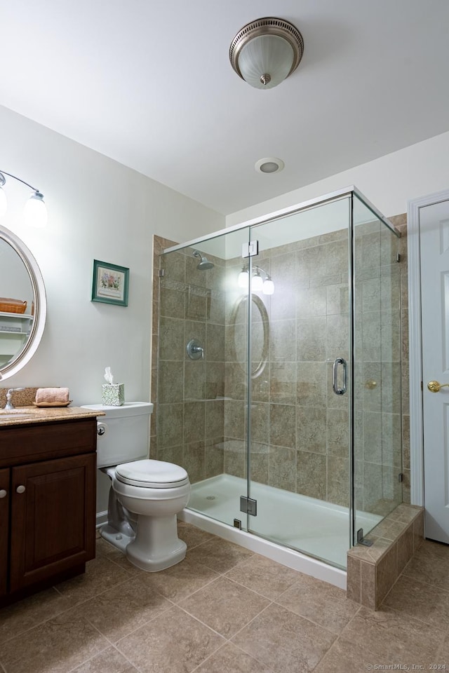 bathroom with toilet, vanity, tile patterned floors, and an enclosed shower