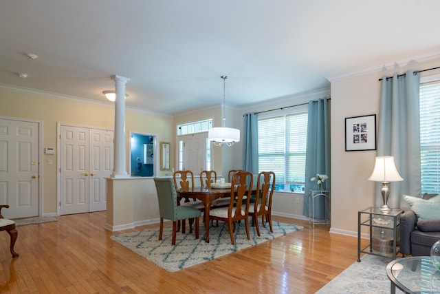 dining space featuring decorative columns, light hardwood / wood-style flooring, and ornamental molding