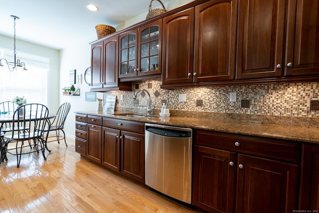 kitchen with stone counters, dishwasher, pendant lighting, and light wood-type flooring