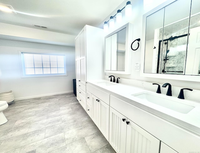 bathroom featuring vanity, toilet, and a shower with door