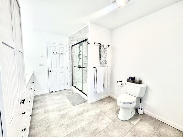 bathroom with vanity, toilet, and a shower with shower door