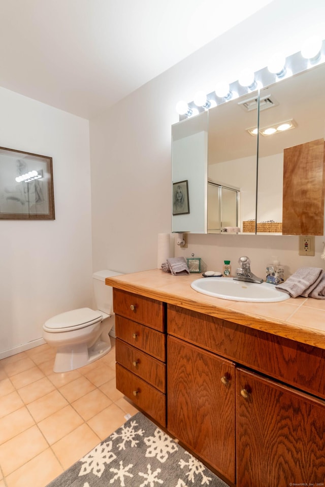 bathroom featuring walk in shower, tile patterned flooring, vanity, and toilet