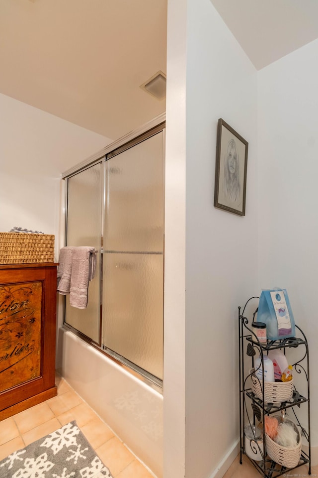 bathroom with tile patterned floors and bath / shower combo with glass door