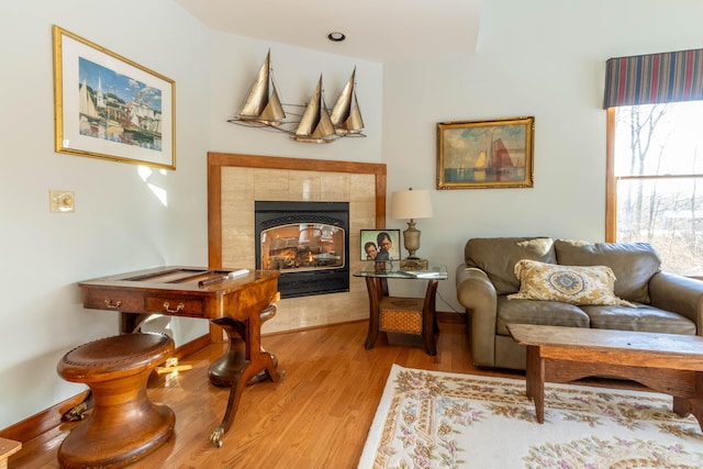 sitting room featuring light wood-type flooring and a tiled fireplace