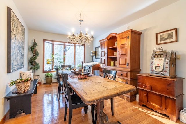 dining room with light hardwood / wood-style floors and an inviting chandelier