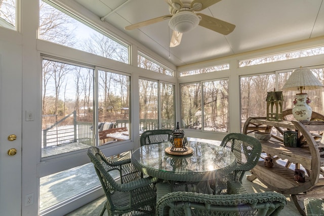 sunroom with ceiling fan, plenty of natural light, and vaulted ceiling