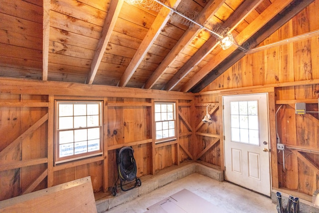 interior space with lofted ceiling with beams, a healthy amount of sunlight, and wood ceiling