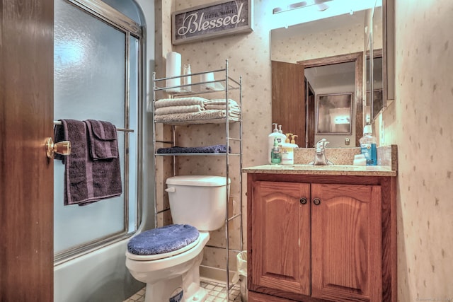 full bathroom featuring vanity, combined bath / shower with glass door, and toilet