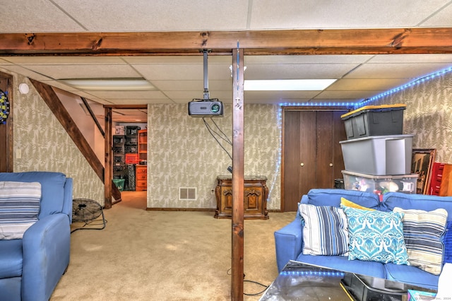 basement with a paneled ceiling and carpet floors