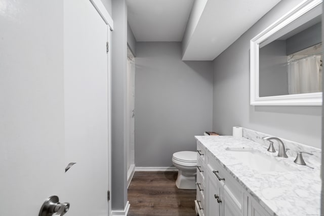 bathroom featuring curtained shower, hardwood / wood-style floors, vanity, and toilet