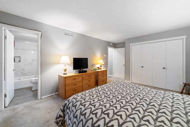 carpeted bedroom featuring ensuite bathroom and a closet