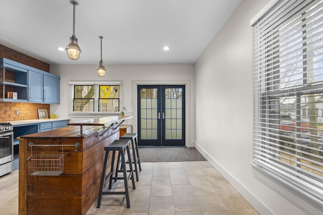 kitchen with french doors, hanging light fixtures, blue cabinets, a kitchen bar, and light tile patterned flooring