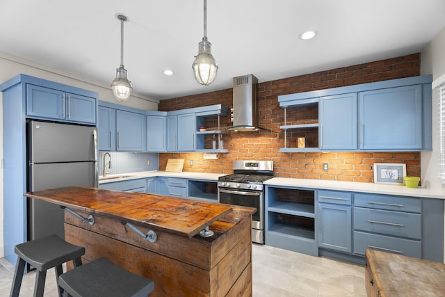 kitchen with decorative backsplash, appliances with stainless steel finishes, sink, blue cabinetry, and wall chimney range hood