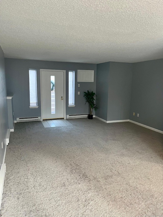 interior space with a textured ceiling and baseboard heating