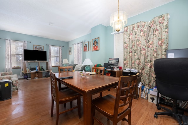 dining area with hardwood / wood-style floors and a chandelier