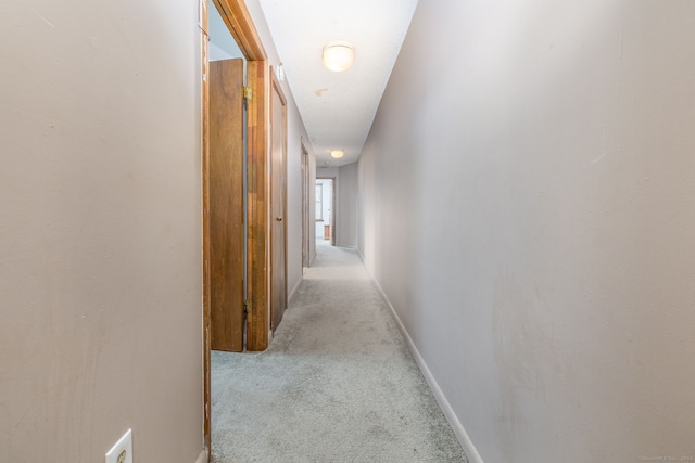 hall with light colored carpet