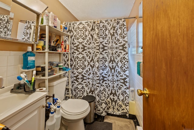 full bathroom with shower / bath combination with curtain, a textured ceiling, toilet, and tile walls