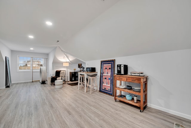 interior space with light wood-type flooring and vaulted ceiling