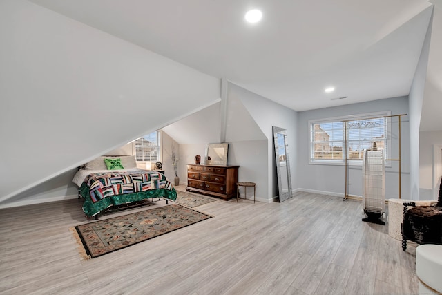 bedroom with light hardwood / wood-style floors and lofted ceiling