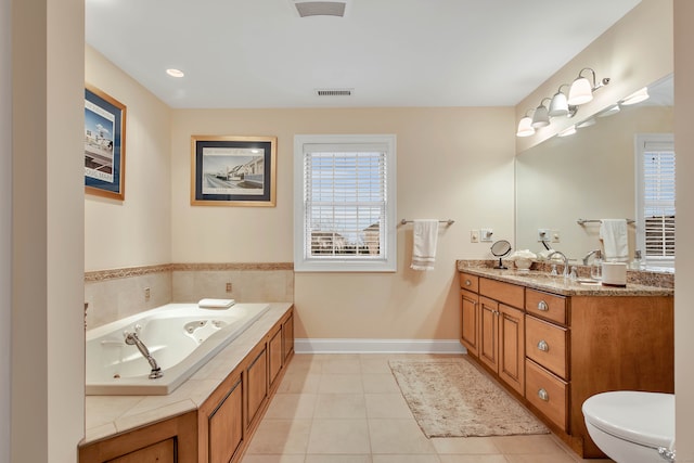 bathroom with a washtub, vanity, tile patterned floors, and toilet