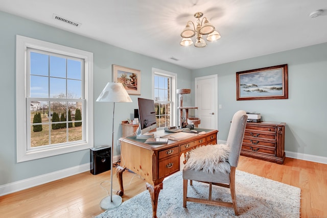 home office featuring light hardwood / wood-style floors, plenty of natural light, and a notable chandelier