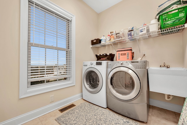 laundry room featuring light tile patterned floors, sink, and washing machine and clothes dryer