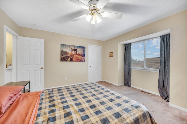 carpeted bedroom with ceiling fan and a textured ceiling