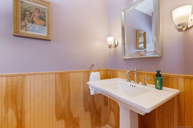 bathroom featuring wood walls