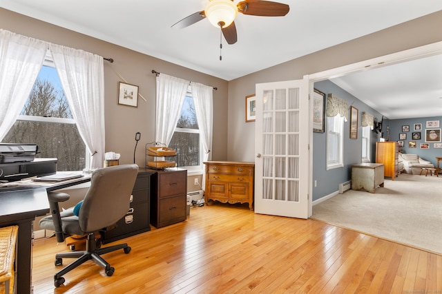 office area with ceiling fan, lofted ceiling, a baseboard heating unit, and light wood-type flooring