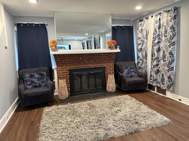 living room featuring dark hardwood / wood-style flooring, a fireplace, and ornamental molding