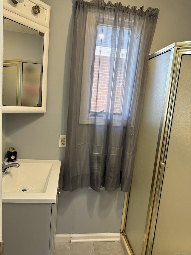 bathroom with walk in shower, vanity, and tile patterned flooring